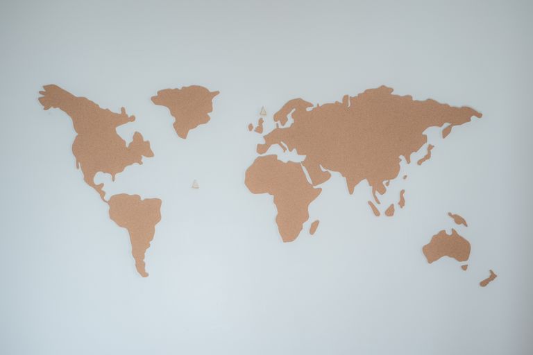 A minimalist cork board world map displayed on a white wall provides modern decor inspiration. Institutional Autonomy governance explainer showing how nations hold their shape through systems and structural resilience.