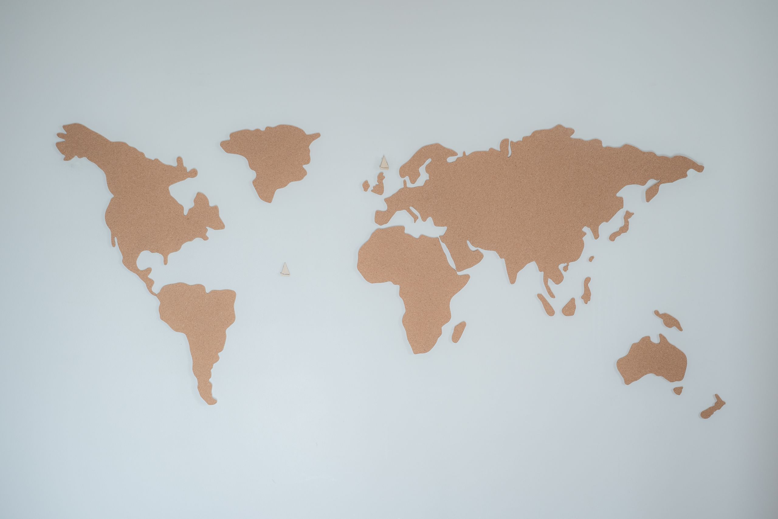 A minimalist cork board world map displayed on a white wall provides modern decor inspiration. Institutional Autonomy governance explainer showing how nations hold their shape through systems and structural resilience.