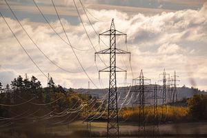 Electric pylons stretch across a picturesque autumn landscape, under a dramatic sky. geoeconomics and energy framework