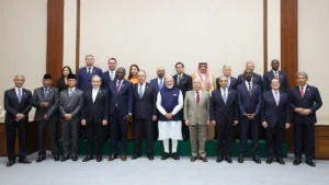 Delegates and officials at a BRICS India 2026 ministerial meeting, standing for a formal group photograph with flags and summit backdrop; no heads of state present.